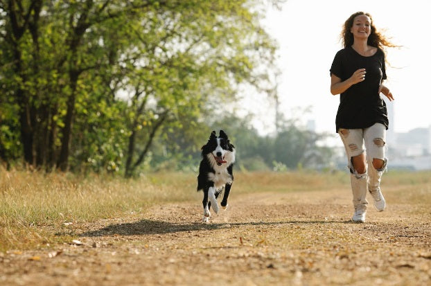 Woman running with dog who has healthy joints from the omega-3 fatty acids in green-lipped mussels